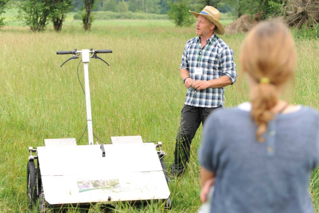 Landwirt Christian Fendt demonstrierte das elektrisch betriebene Samensammelgerät „e-beetle“, das dazu dient, aus artenreichen Wiesenbeständen Saatgut zu gewinnen, indem die Samen der Wiesenpflanzen mit einer rotierenden Bürste „ausgefegt“ werden.