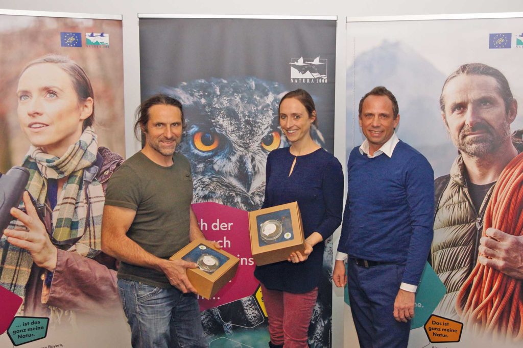 Ambassadors Alexander Huber and Dr. Auguste von Bayern meet Thorsten Glauber, Minister of State for the Environment and Consumer Protection. They stand in front of 2 campaign posters.