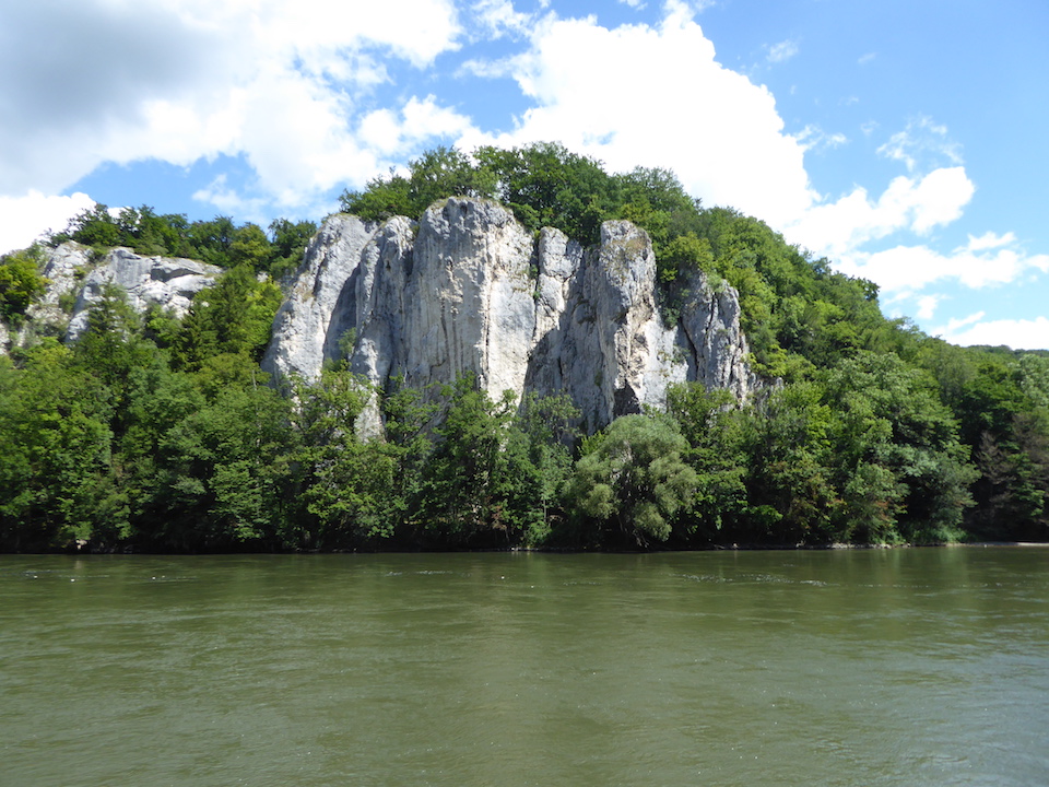 Hohe Felswände, davor fließt der Fluss Donau.
