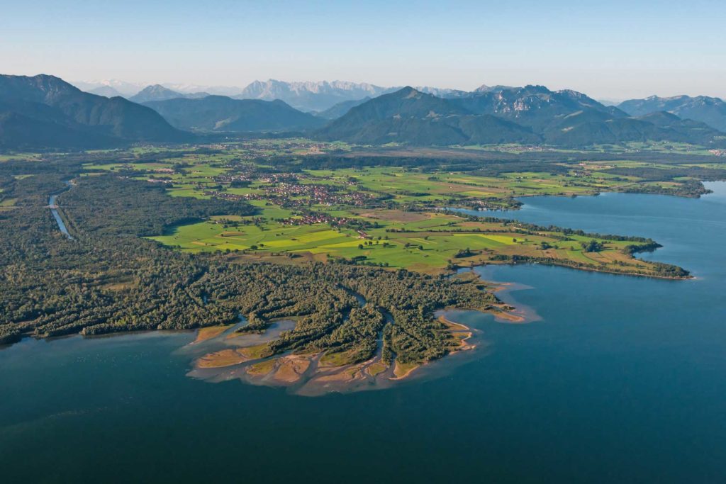 Landschaftsbild mit Bergen, Grünflächen und Wasser