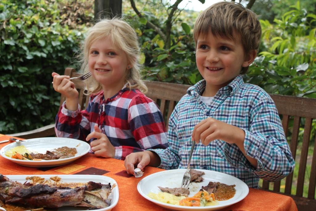 Zwei lächelnde Kinder beim Essen