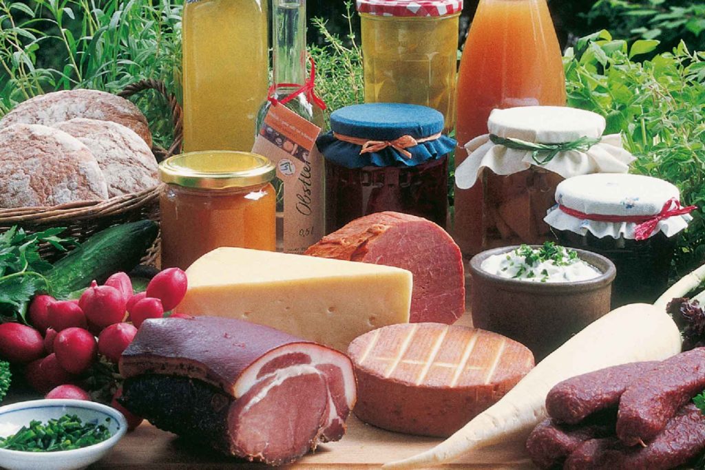 Bunte Auswahl an Marmeladen, Fleisch, Wurst, Käse, Brot und Gemüse