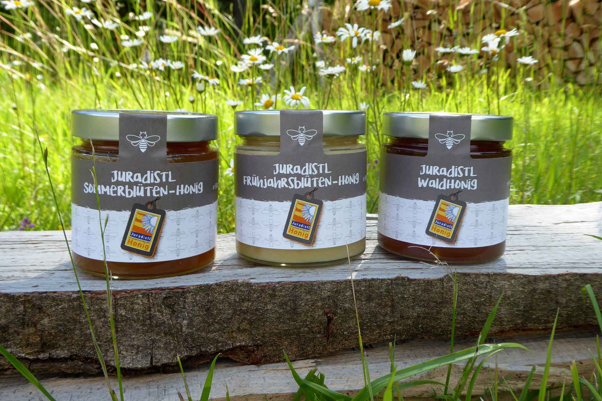 Drei Honiggläser mit verschiedenen Honigsorten