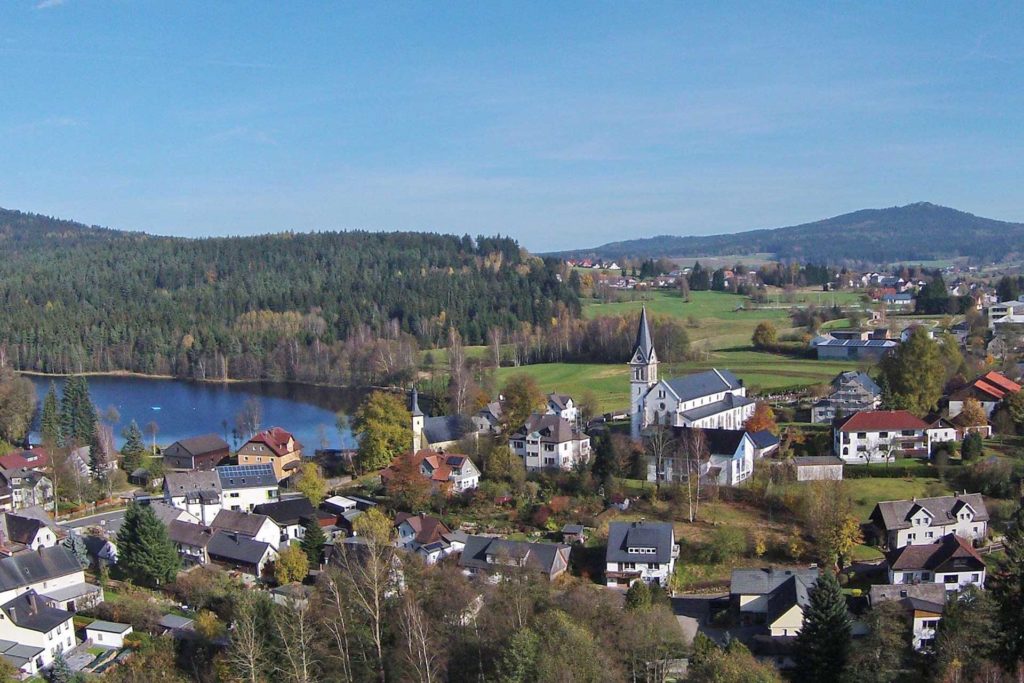 Dorf umgeben von Natur und einem See