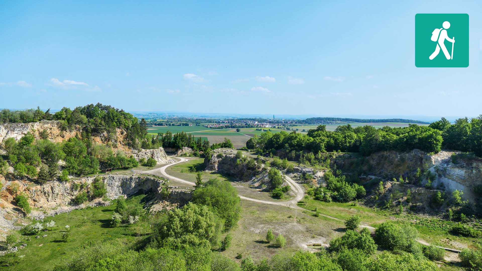 Landschaft mit Hangkanten, die mit Nadelbäumen bewachsen sind.