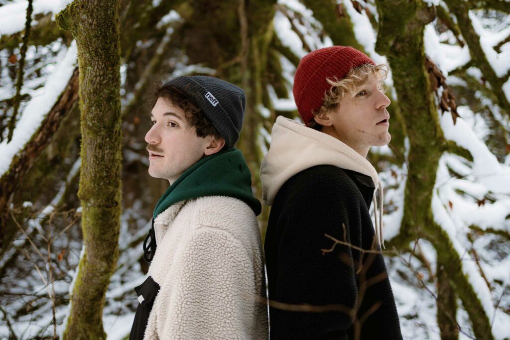 Die Brüder Matti und Jakob Bruckner stehen Rücken an Rücken im Wald.